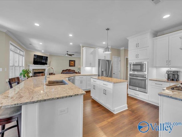 414 Wood Sage Ln, Huntsville, AL 35824 - kitchen with dark wood-style floors, crown molding, a kitchen island, stainless steel appliances, and a sink