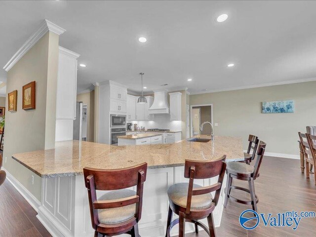 414 Wood Sage Ln, Huntsville, AL 35824 - kitchen with white cabinets, a sink, appliances with stainless steel finishes, dark wood finished floors, and custom range hood
