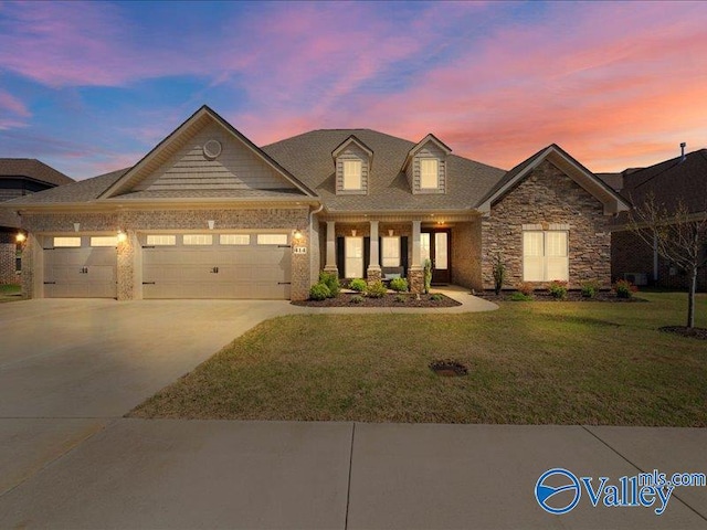 414 Wood Sage Ln, Huntsville, AL 35824 - view of front facade with concrete driveway, a garage, stone siding, and a front lawn