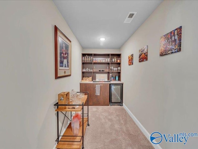 414 Wood Sage Ln, Huntsville, AL 35824 - home office featuring baseboards, visible vents, a dry bar, wine cooler, and light colored carpet