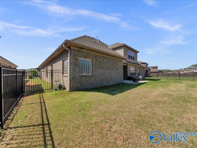 414 Wood Sage Ln, Huntsville, AL 35824 - rear view of house with a yard, brick siding, and a fenced backyard