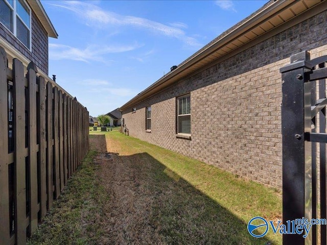 414 Wood Sage Ln, Huntsville, AL 35824 - view of side of home featuring brick siding, fence, and a lawn