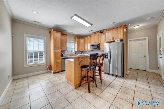 kitchen featuring light tile patterned floors, appliances with stainless steel finishes, light countertops, a center island, and visible vents