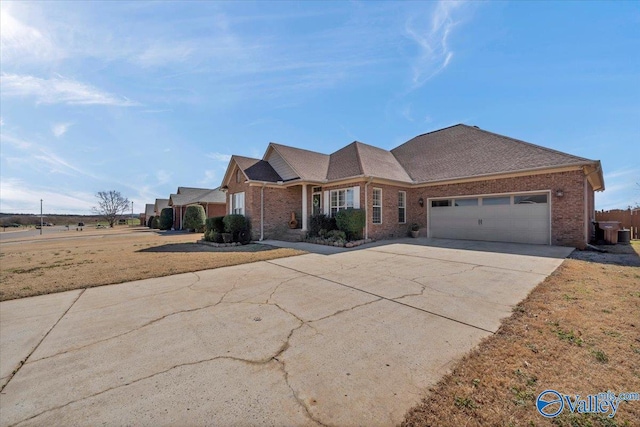 ranch-style home featuring driveway, an attached garage, and brick siding