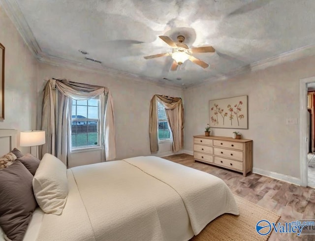 bedroom with baseboards, wood finished floors, a ceiling fan, and crown molding