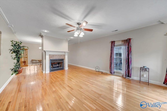unfurnished living room featuring visible vents, ornamental molding, ceiling fan, and light wood finished floors