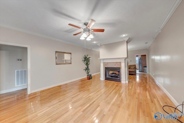unfurnished living room featuring a fireplace, visible vents, ceiling fan, and ornamental molding