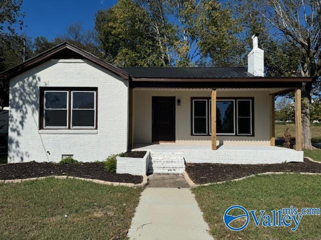 view of front of property featuring covered porch and a front lawn