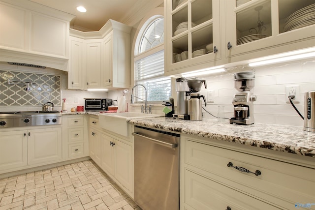 kitchen featuring light stone countertops, sink, stainless steel appliances, and tasteful backsplash