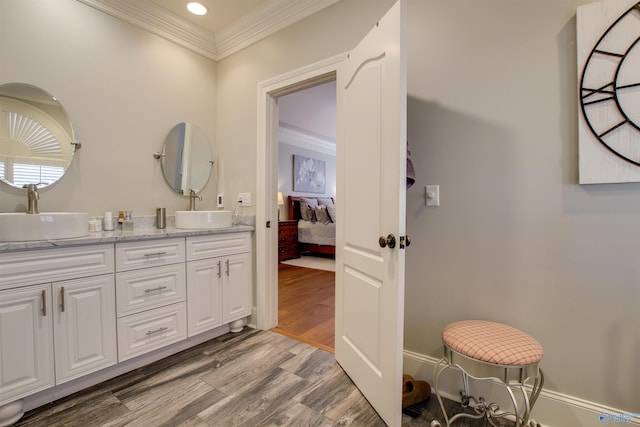 bathroom with vanity, crown molding, and hardwood / wood-style floors