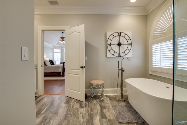 bathroom featuring a tub to relax in, ceiling fan, ornamental molding, and hardwood / wood-style floors