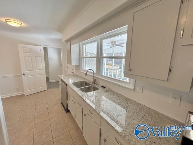 kitchen with decorative backsplash, light stone counters, sink, and white cabinets