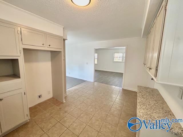 kitchen with light stone counters, light tile patterned flooring, and a textured ceiling