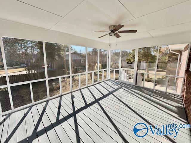 unfurnished sunroom with ceiling fan