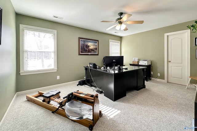 carpeted office space featuring ceiling fan