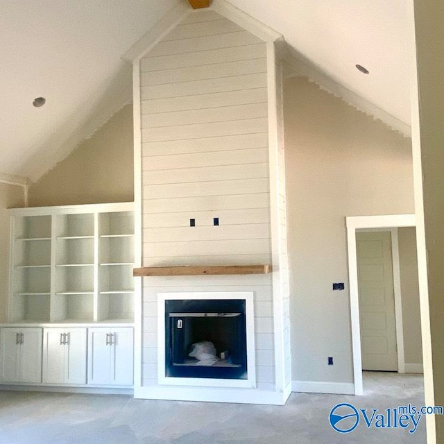 unfurnished living room featuring a fireplace and lofted ceiling with beams