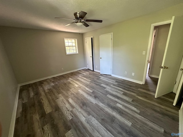 unfurnished bedroom featuring ceiling fan, dark wood-type flooring, and a textured ceiling