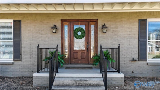 view of exterior entry with brick siding