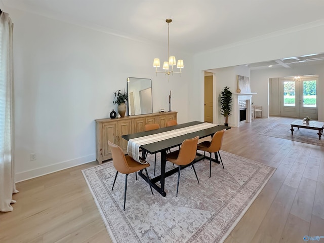 dining room featuring ornamental molding, an inviting chandelier, and light hardwood / wood-style flooring