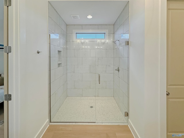 bathroom featuring wood-type flooring and an enclosed shower