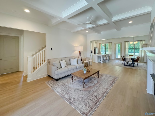 living room featuring ceiling fan, light hardwood / wood-style flooring, and beam ceiling