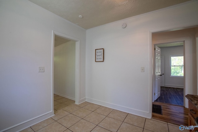 spare room with visible vents, ornamental molding, and light tile patterned floors