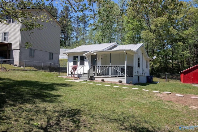 bungalow-style house with fence, metal roof, a porch, and a front lawn