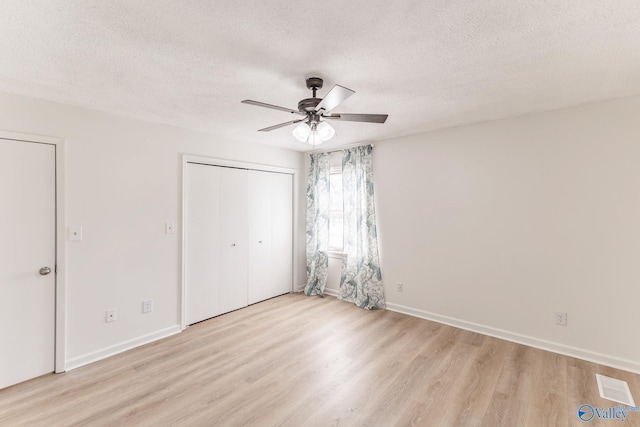 unfurnished bedroom with ceiling fan, light hardwood / wood-style floors, and a textured ceiling