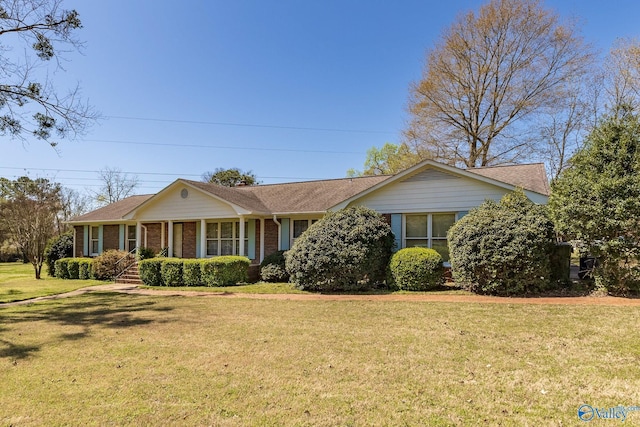 ranch-style house featuring covered porch and a front yard