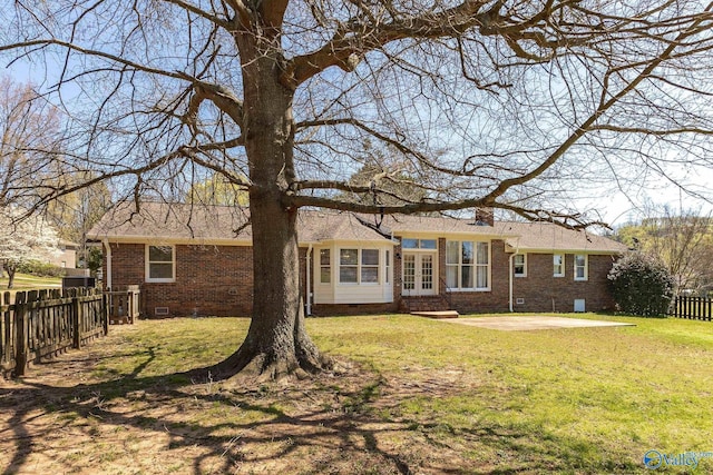 rear view of property featuring a patio, french doors, and a lawn