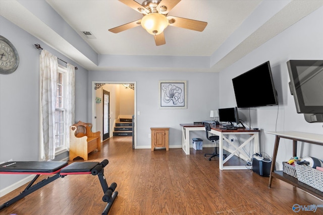 office area featuring hardwood / wood-style flooring, a raised ceiling, and ceiling fan