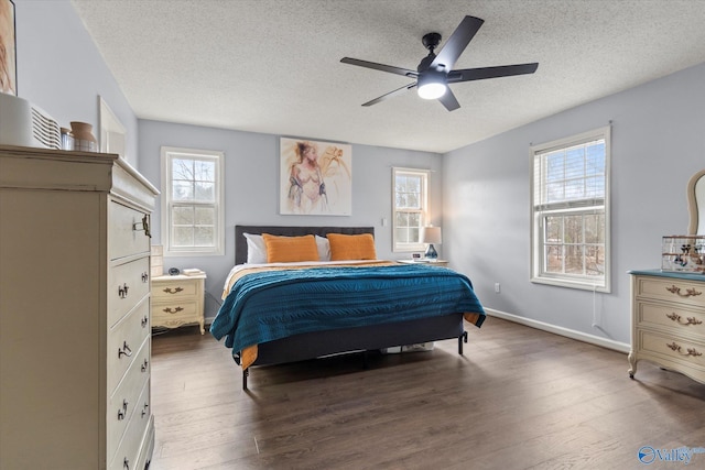 bedroom featuring ceiling fan, dark hardwood / wood-style flooring, and a textured ceiling