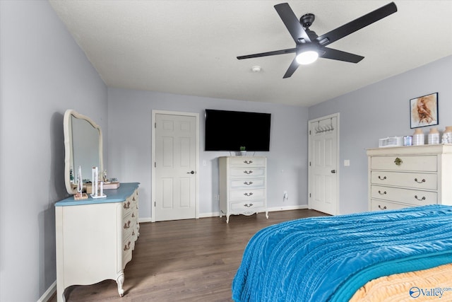 bedroom featuring dark wood-type flooring, ceiling fan, and a textured ceiling