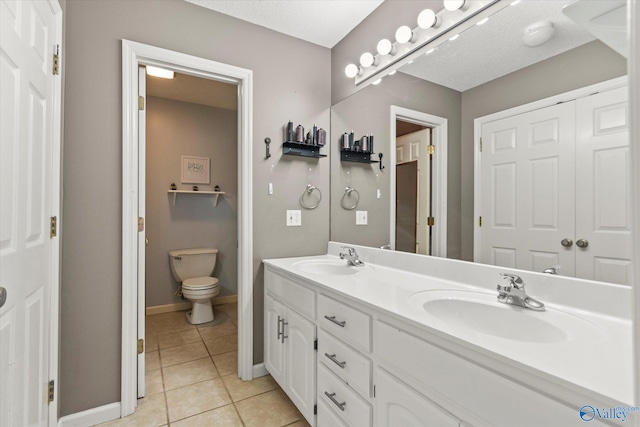 bathroom with vanity, tile patterned floors, and toilet