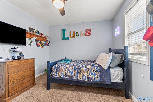 bedroom featuring light carpet, a textured ceiling, and ceiling fan