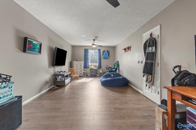 interior space featuring ceiling fan, hardwood / wood-style floors, and a textured ceiling