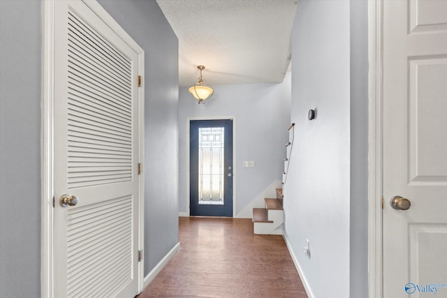 entrance foyer with dark hardwood / wood-style flooring and a textured ceiling