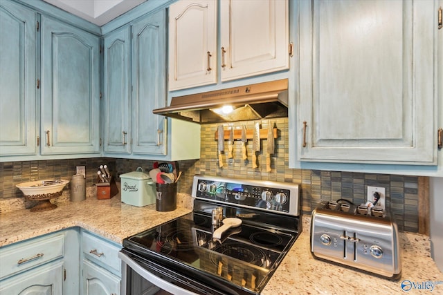 kitchen with blue cabinets, electric range oven, and decorative backsplash