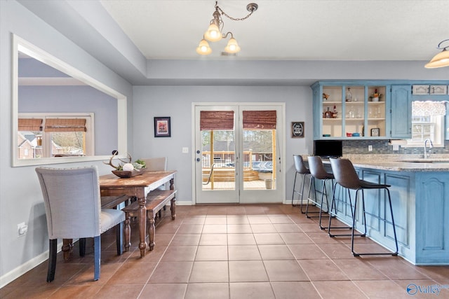 tiled dining room featuring a chandelier and sink