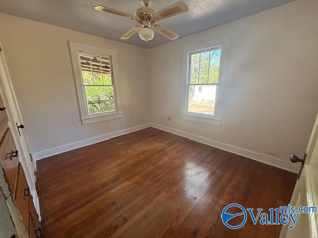 unfurnished room featuring ceiling fan, baseboards, plenty of natural light, and wood finished floors