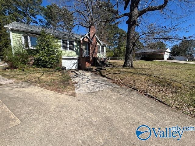 view of home's exterior with concrete driveway, an attached garage, and a chimney