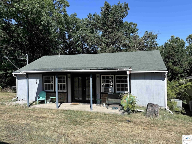 view of front facade featuring french doors, a front lawn, a patio area, and cooling unit