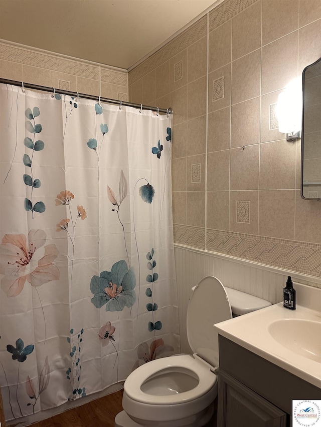 bathroom with curtained shower, toilet, vanity, and wood finished floors