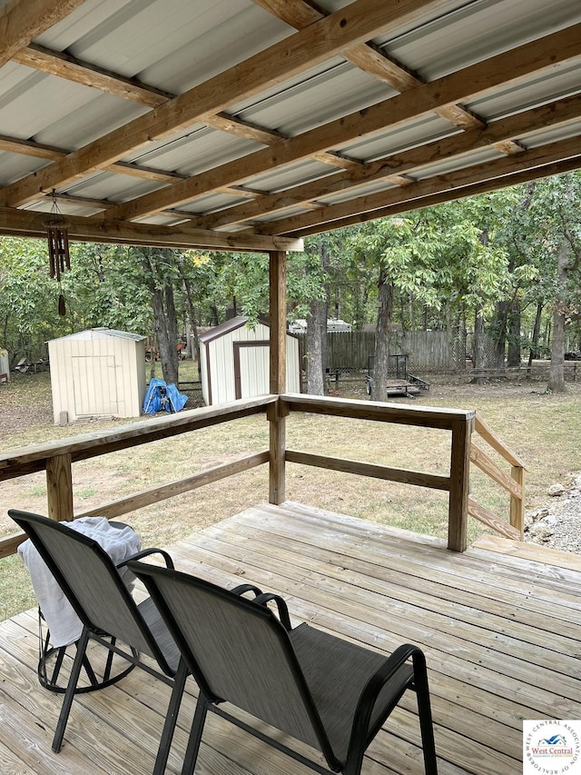 deck featuring an outbuilding, fence, and a storage shed