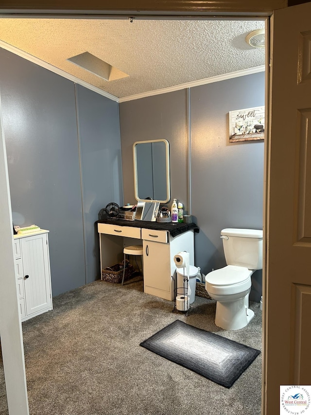 half bathroom with toilet, ornamental molding, a textured ceiling, and vanity