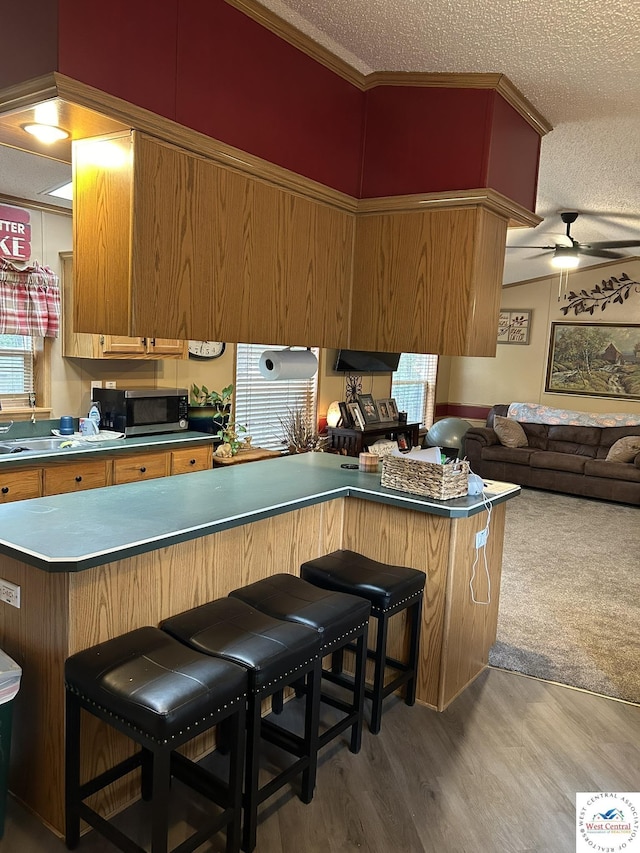 kitchen with a peninsula, a breakfast bar area, and stainless steel microwave