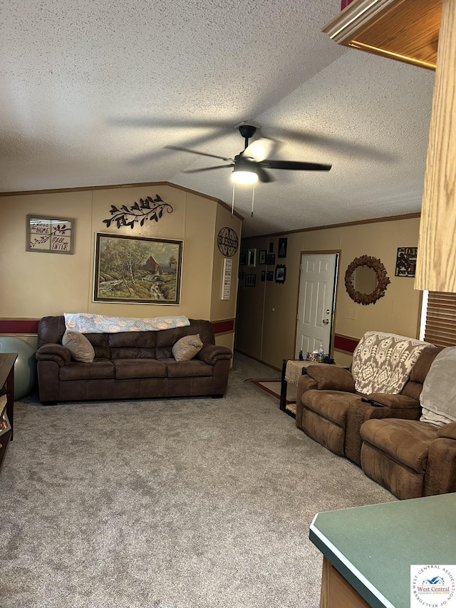 living room with a textured ceiling, ceiling fan, carpet floors, vaulted ceiling, and ornamental molding