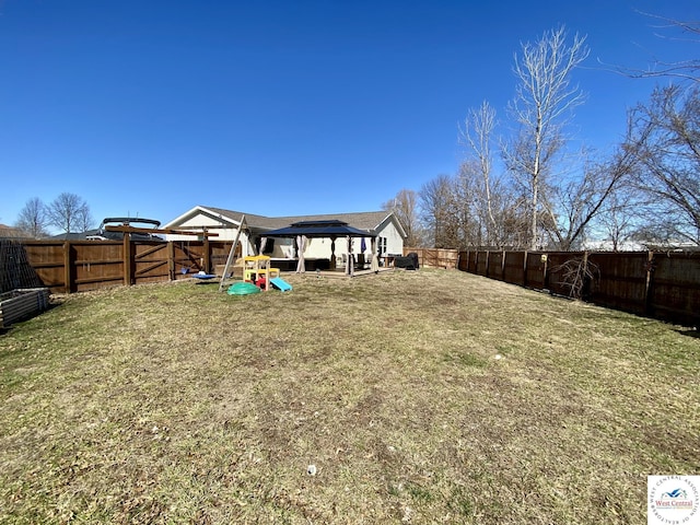 view of yard featuring a fenced backyard and a playground