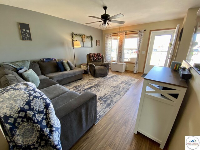 living area with wood finished floors and a ceiling fan