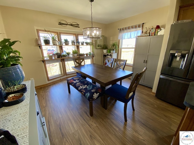 dining area featuring a notable chandelier, baseboards, and wood finished floors